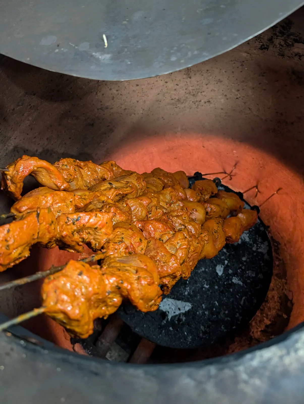 Chicken tikka skewers cooking in the tandoor